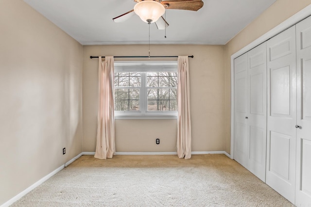 unfurnished bedroom with a closet, baseboards, carpet, and a ceiling fan