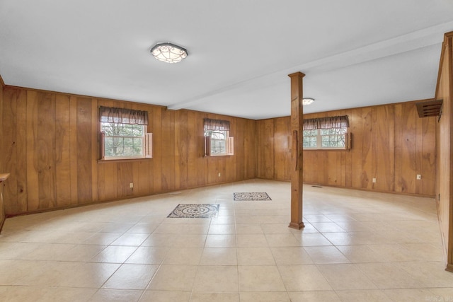 basement featuring light tile patterned floors, a healthy amount of sunlight, and baseboards