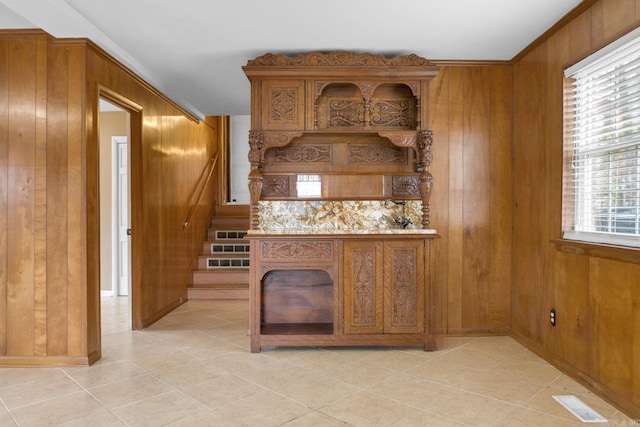 details featuring wooden walls, crown molding, and visible vents