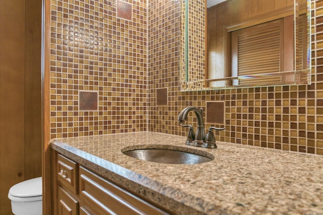 bathroom featuring backsplash, vanity, and toilet