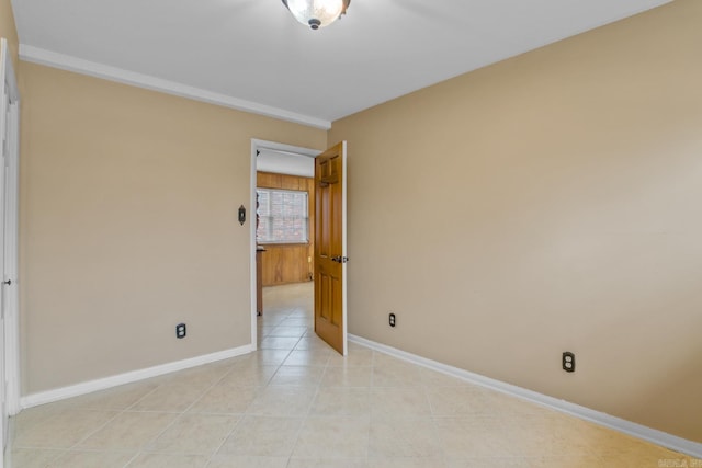 empty room featuring light tile patterned floors and baseboards