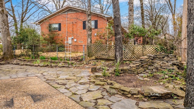 back of property featuring brick siding and fence