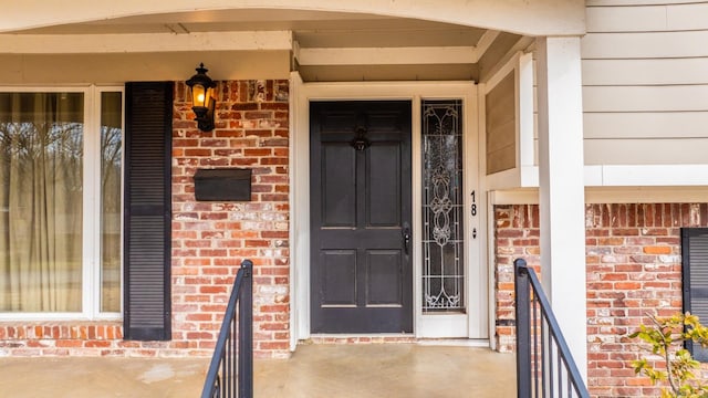 doorway to property featuring brick siding