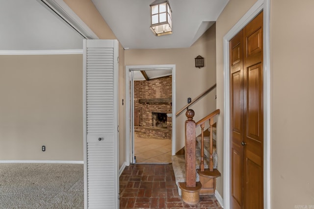 entrance foyer featuring brick floor, stairway, and baseboards