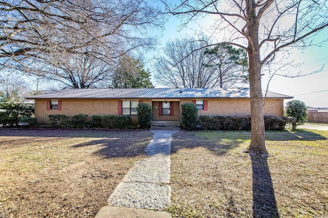 ranch-style house featuring brick siding and a front yard