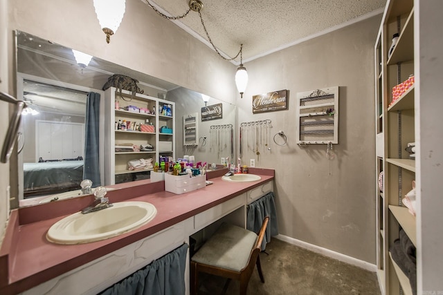 full bathroom featuring a textured ceiling, double vanity, baseboards, and a sink