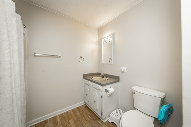 full bathroom with vanity, wood finished floors, baseboards, crown molding, and toilet