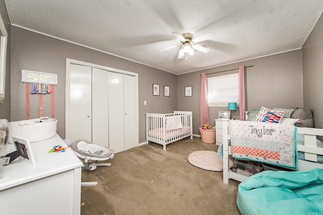 carpeted bedroom with a closet, a textured ceiling, and ceiling fan