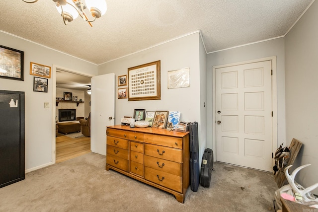 interior space with light carpet, a fireplace, a textured ceiling, and crown molding