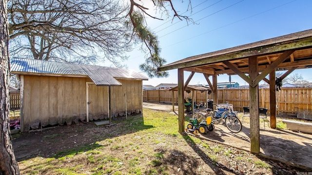 view of yard featuring an outbuilding, a shed, and fence