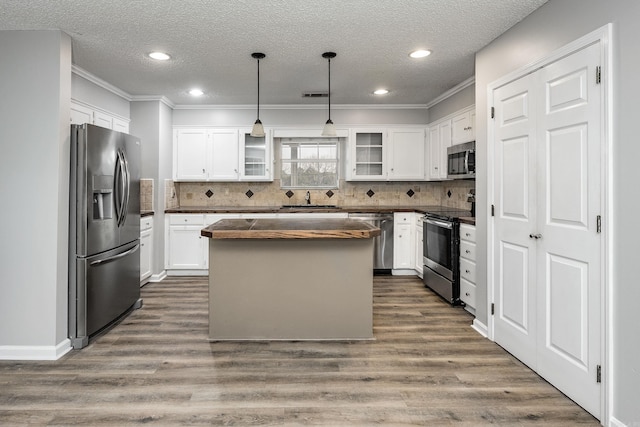 kitchen featuring a sink, glass insert cabinets, appliances with stainless steel finishes, and dark wood finished floors