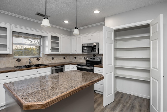 kitchen featuring a sink, stainless steel appliances, dark wood-type flooring, white cabinets, and dark countertops