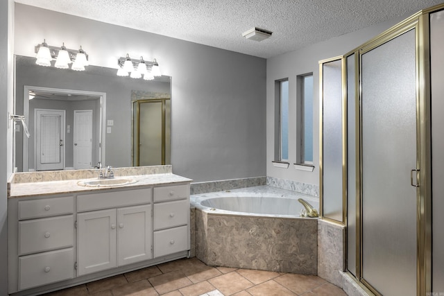 bathroom featuring tile patterned floors, a stall shower, a bath, a textured ceiling, and vanity