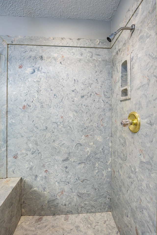 bathroom with a shower and a textured ceiling