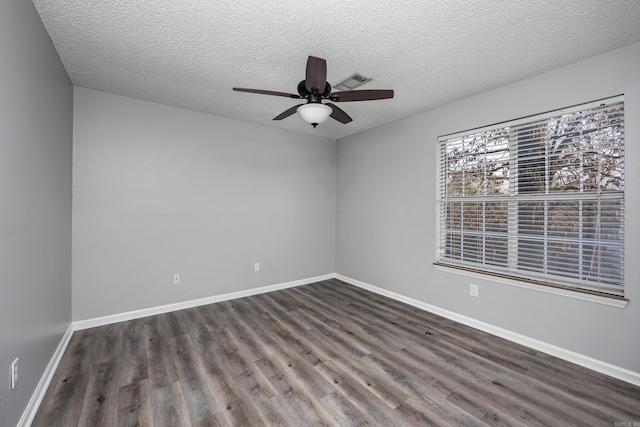 unfurnished room with a textured ceiling, baseboards, dark wood-type flooring, and ceiling fan