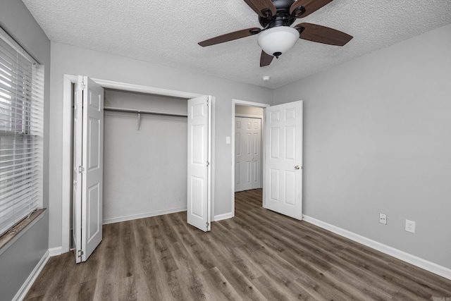 unfurnished bedroom featuring wood finished floors, baseboards, ceiling fan, a closet, and a textured ceiling