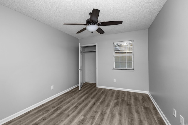 unfurnished bedroom featuring a textured ceiling, wood finished floors, a closet, baseboards, and ceiling fan