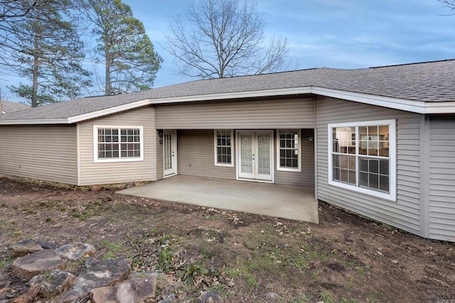 back of property with french doors, a patio, and roof with shingles