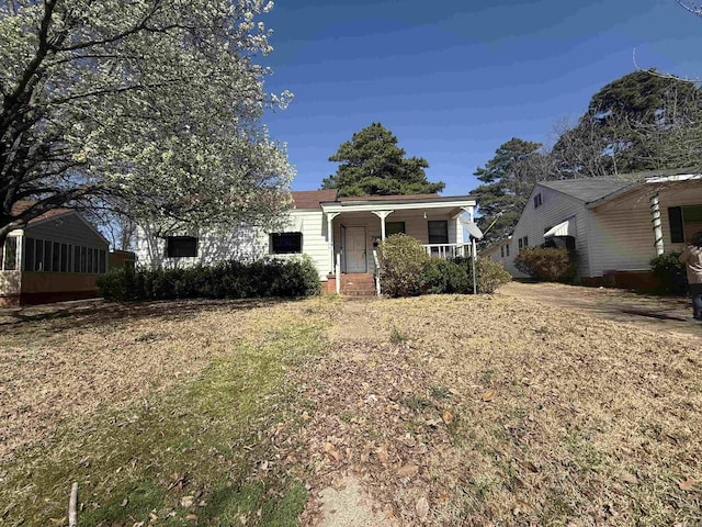 view of front of home with covered porch and a front lawn