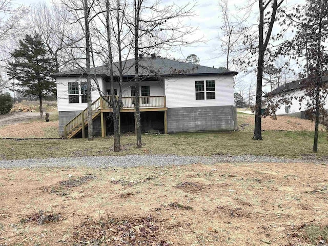 rear view of house with stairs, a deck, and a lawn