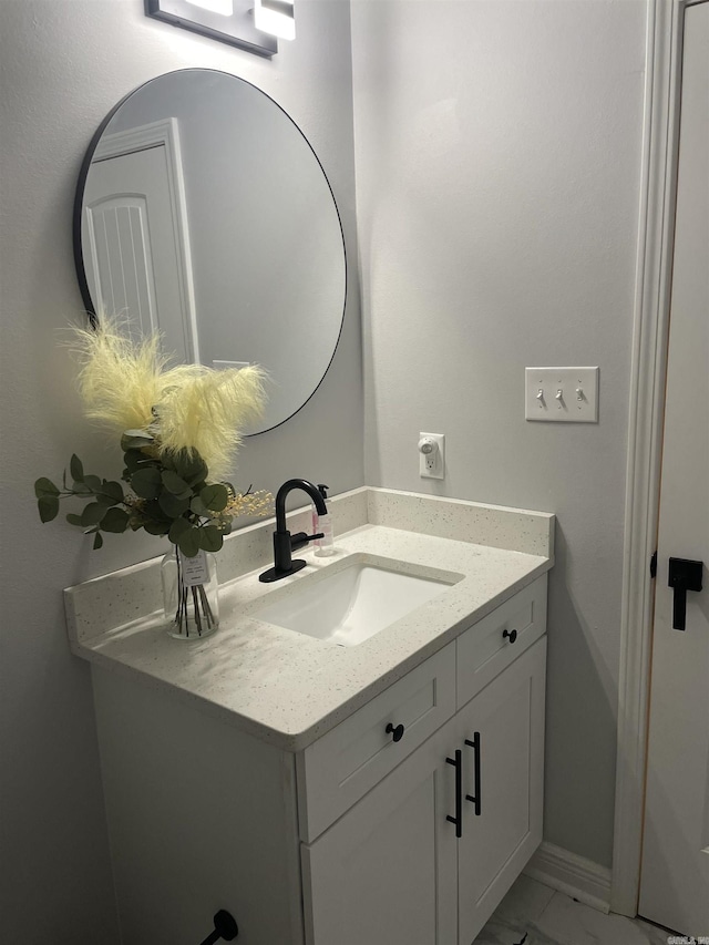 bathroom with vanity, baseboards, and marble finish floor