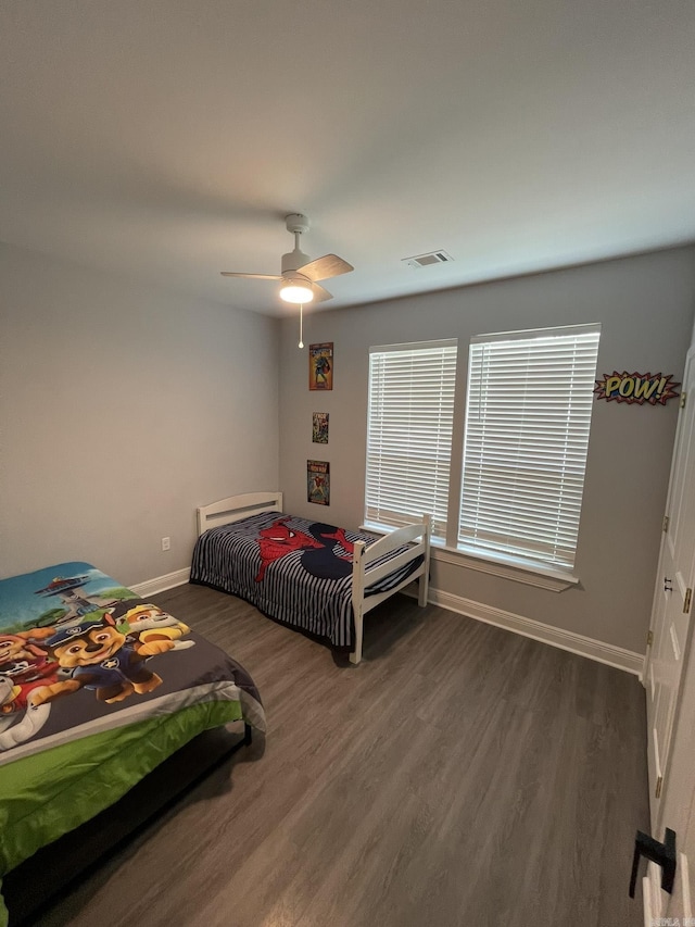 bedroom with visible vents, ceiling fan, baseboards, and wood finished floors