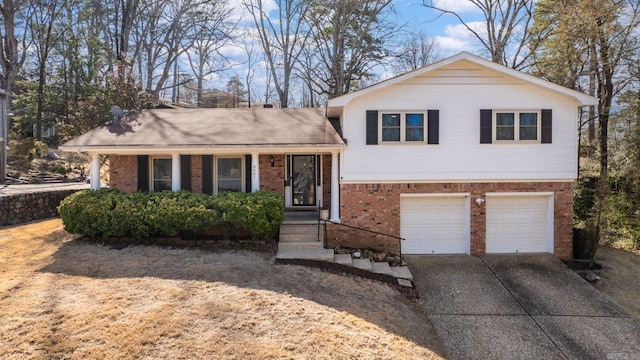 tri-level home featuring a garage, brick siding, and concrete driveway