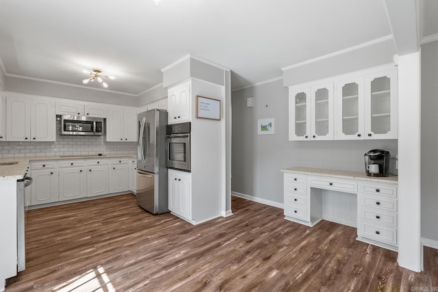 kitchen with stainless steel appliances, dark wood finished floors, crown molding, and white cabinets