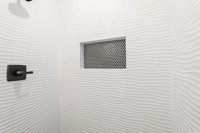 interior details with a tile shower