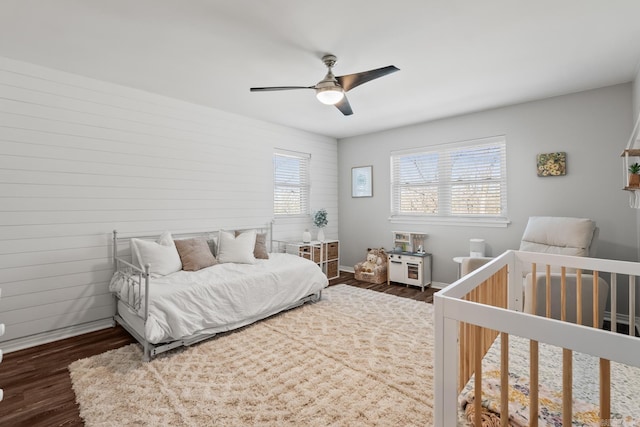 bedroom with dark wood-type flooring, baseboards, and ceiling fan