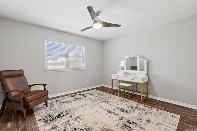 living area with a ceiling fan, wood finished floors, and baseboards