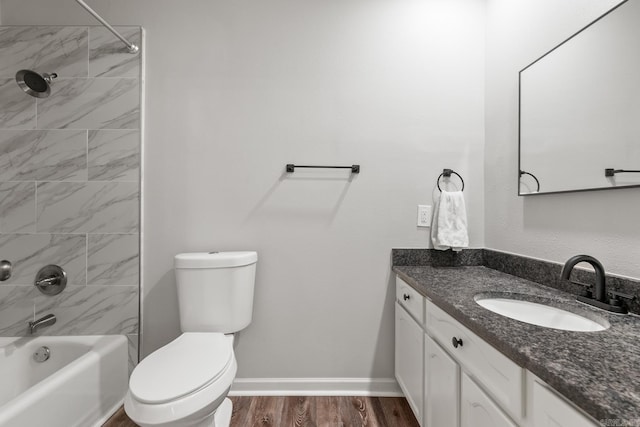 bathroom featuring vanity, wood finished floors, baseboards, shower / tub combination, and toilet