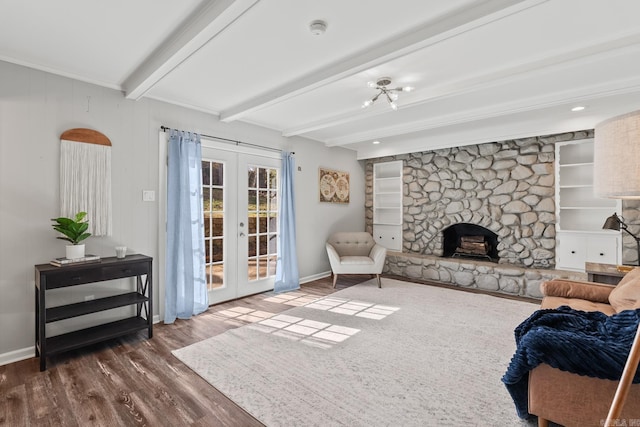 living room featuring beam ceiling, dark wood finished floors, french doors, a stone fireplace, and baseboards