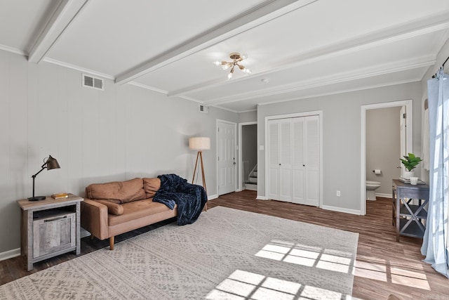 living area with beam ceiling, visible vents, baseboards, and wood finished floors