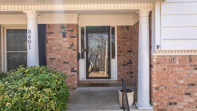 entrance to property featuring brick siding and a porch