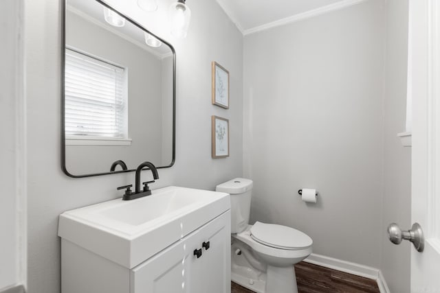 bathroom featuring baseboards, toilet, wood finished floors, and vanity