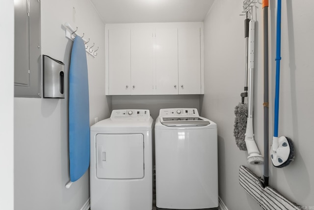 clothes washing area with cabinet space, washer and dryer, and electric panel