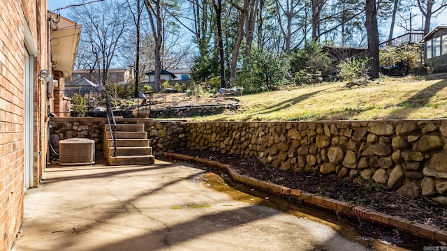 view of yard featuring a patio area, central air condition unit, and stairs