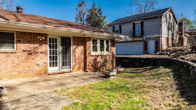 view of front of property with a front yard, a patio area, and brick siding