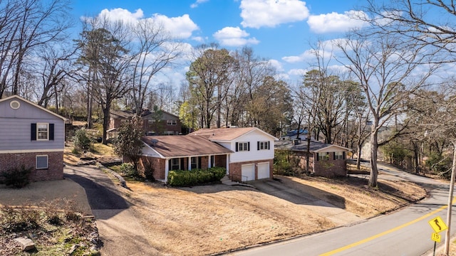 exterior space featuring brick siding, driveway, and a garage