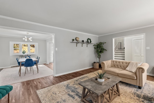 living area with baseboards, wood finished floors, and crown molding