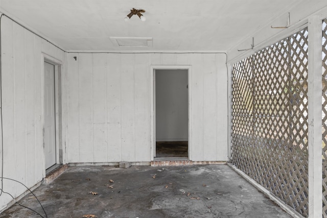 exterior space featuring attic access and unfinished concrete floors