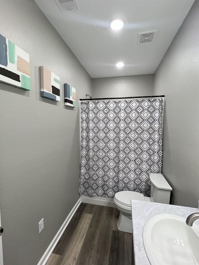 full bath featuring visible vents, curtained shower, toilet, and wood finished floors