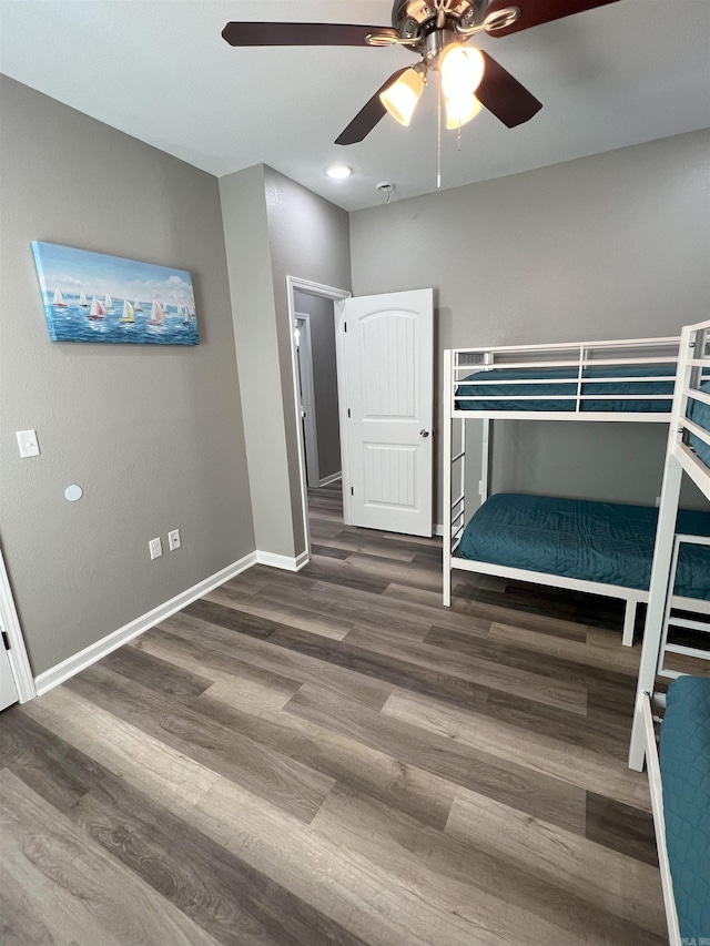 unfurnished bedroom with ceiling fan, baseboards, and wood finished floors