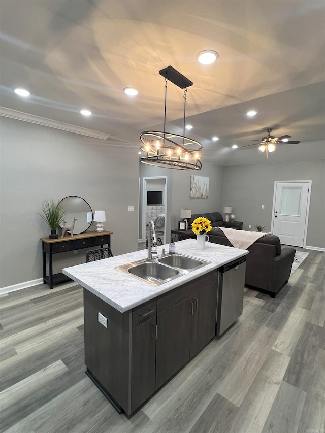 kitchen featuring a sink, open floor plan, light countertops, stainless steel dishwasher, and a kitchen island with sink