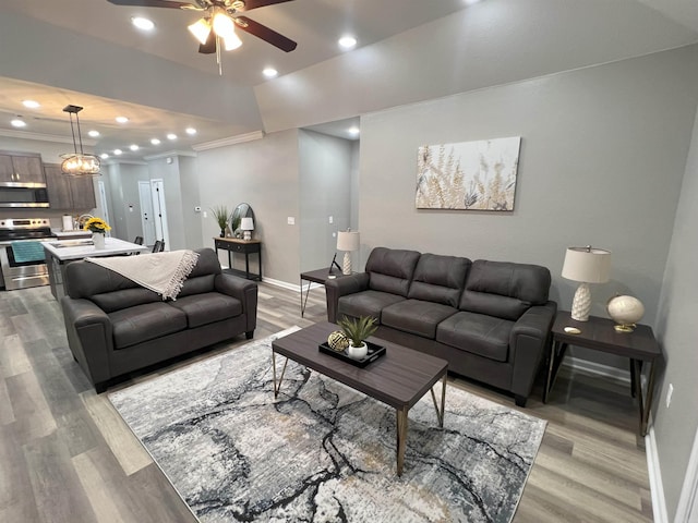 living area featuring recessed lighting, light wood-style floors, baseboards, and ornamental molding