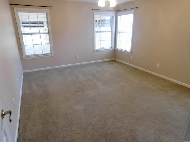 carpeted spare room featuring baseboards