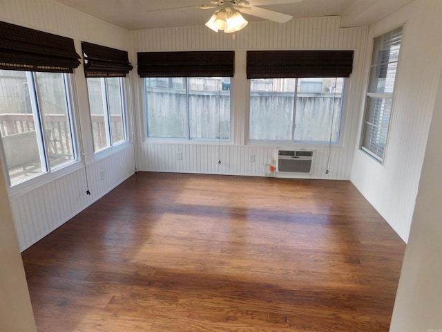 unfurnished sunroom featuring a wall mounted air conditioner and ceiling fan