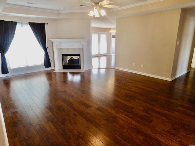 unfurnished living room featuring a fireplace, crown molding, baseboards, and wood finished floors