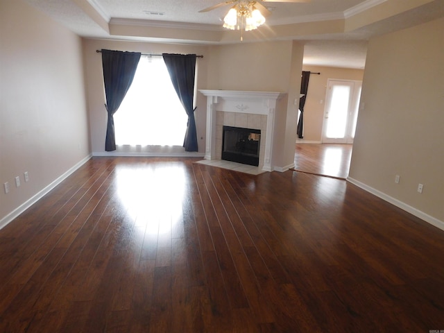 unfurnished living room featuring ornamental molding, wood finished floors, baseboards, and a tile fireplace